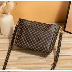 Dettaglio della borsa a secchiello stampata con fibbia dorata e texture in pelle