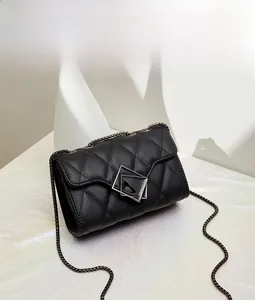 Detail of black quilted leather crossbody bag with silver geometric buckle and chain strap