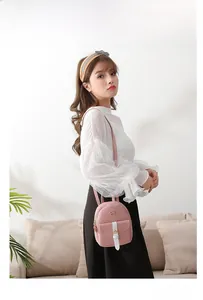 Mini pink leather backpack for women with golden bow detail shown on a model