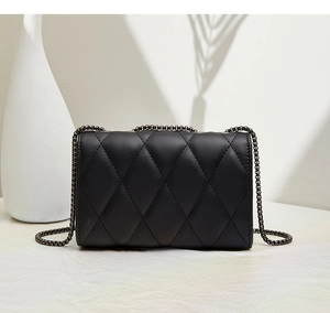 Detail shot of quilted black chain bag featuring a matte finish and elegant gunmetal chain