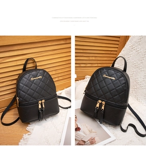 Détail d'un mini sac à dos noir matelassé avec surpiqûres en losange et logo doré