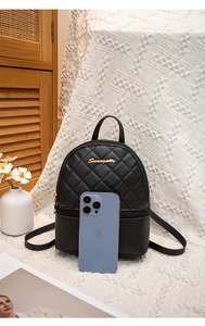 Détail d'un mini sac à dos matelassé noir avec logo doré et fermeture éclair bidirectionnelle