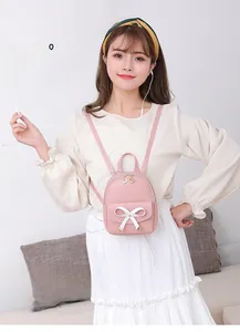 Détail du mini sac à dos rose avec nœud blanc et port pour écouteurs intégré