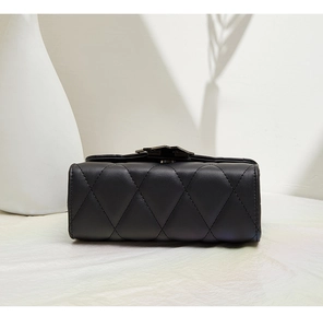 Detailed close-up of black quilted leather stitching and smooth texture on women's bag