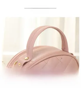 Close-up of soft padded handle on light pink quilted handbag with premium stitching