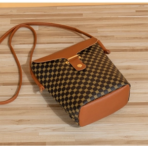 Detail of vintage crossbody bucket bag with brown faux leather and golden dot pattern