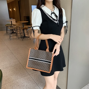 Klassische gemusterte Shopper Tasche mit Streifenband, präsentiert von Model im Café