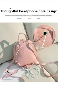 Détail d'un mini sac à dos rose avec œillet métallique pour câble d'écouteurs au dos