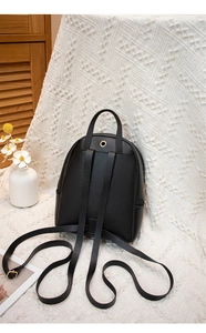 Détail du mini sac à dos noir en cuir grainé avec port casque et boucles dorées