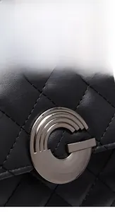 Gros plan sur cuir matelassé noir avec boucle métallique argentée en forme de G