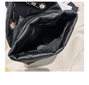 Vue intérieure d'un sac seau noir matelassé avec œillets dorés et rangement spacieux