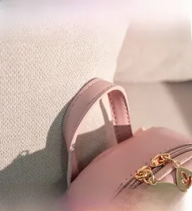Detailed close-up of pink PU leather mini backpack with golden leaf-shaped zippers
