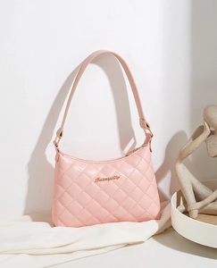 Close-up of pink quilted underarm bag with gold metal logo and refined stitching texture