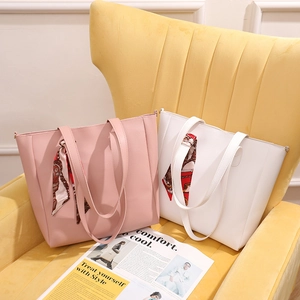 Large capacity tote bags in pink and white with decorative scarves on a yellow chair