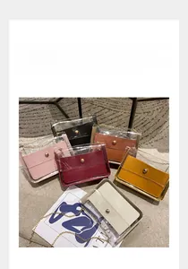 Détail de sacs bandoulière en PVC transparent avec pochettes colorées et chaînes dorées