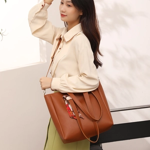 Brown leather large capacity bucket bag with decorative silk scarf on casual model