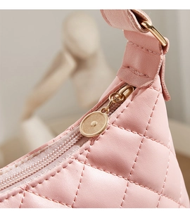 Detail of pink quilted leather shoulder bag with gold-tone zipper and fine stitching