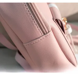Close-up of neat stitching and zipper detail on pink faux leather mini backpack