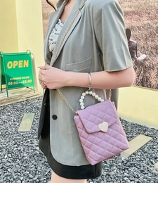 Détail du mini sac matelassé lavande avec poignée en perles et fermoir cœur doré en extérieur