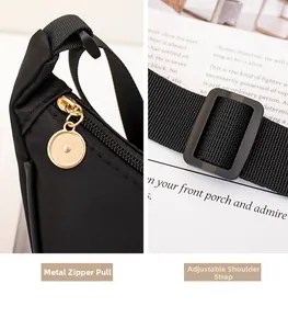 Detail of golden metal zipper pull and adjustable woven shoulder strap on black bag