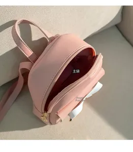 Détails du mini sac à dos rose montrant la poche principale et le compartiment zippé