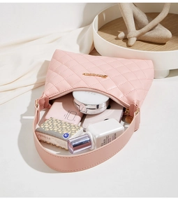 Pink quilted shoulder bag showing interior capacity with phone and cosmetics