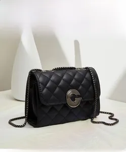 Détail du sac à chaîne matelassé noir avec fermoir rotatif en métal rond et texture raffinée