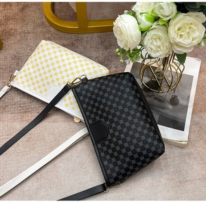 Flat lay of stylish crossbody bags in black and white geometric patterns with gold hardware