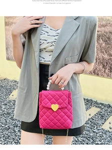 Détail du sac bandoulière matelassé rose rouge avec fermoir cœur et anse perle
