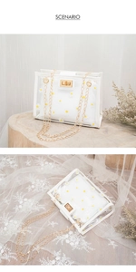 Detail of white semi-transparent PVC daisy crossbody bag with gold chain and turn-lock