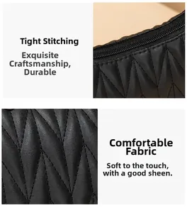 Detail of black embroidered underarm bag with quilted diamond pattern and stitching