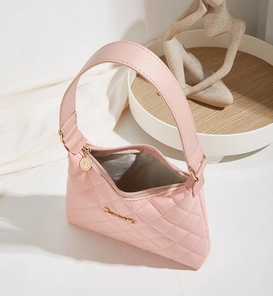Detailed close-up of pink quilted shoulder bag featuring golden logo and hardware