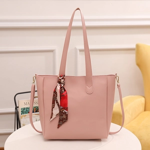 Minimalistische rosa Leder-Einkaufstasche mit Seidenschal-Akzent auf weißem Tisch
