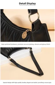 Detail of black pleated shoulder bag with high-polish gold hardware and premium strap