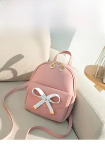 Détail d'un mini sac à dos rose en cuir PU avec nœud blanc et fermeture feuille d'or