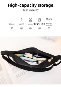 Detail view of black crossbody bag showing spacious interior with zipper and pockets