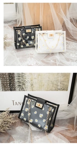 Detail of transparent PVC crossbody bag with white daisy prints and gold chain strap
