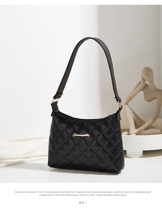Detail of black quilted leather hobo bag featuring gold metal script logo and wide strap