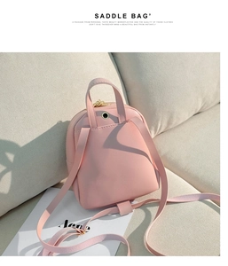 Détail d'un mini sac à dos rose avec port d'écouteurs noir sur cuir synthétique de qualité