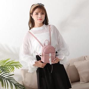 Pink mini backpack for women with golden bow detail and adjustable cross-body straps