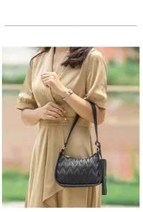 Chic black quilted baguette bag with V-shaped stitching and small matching coin purse pouch