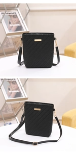 Detail of black woven leather bucket bag with gold metal hardware and adjustable strap