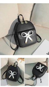 Détail d'un mini sac à dos noir avec texture en cuir et décoration en nœud blanc