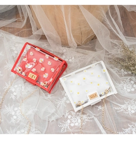 Detailed view of clear PVC daisy print crossbody bags with gold chains and metal locks