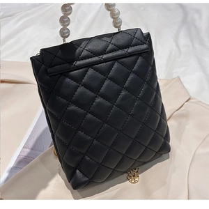 Détail du sac de téléphone matelassé noir avec poignée en perles et chaîne dorée
