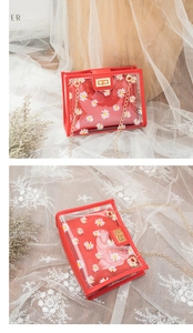 Detailed view of red daisy inner pouch with transparent PVC outer and gold chain strap