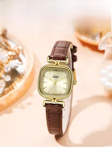Detail of square gold watch with champagne sunray dial and brown leather strap