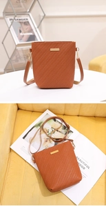 Detail of caramel brown woven crossbody bag with gold metal trim and adjustable strap