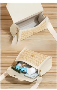 Détail du sac bandoulière en paille crème montrant l'espace pour téléphone et maquillage
