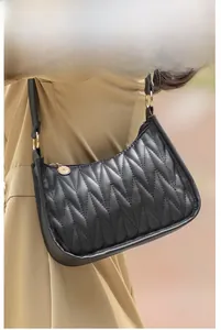 Detail of black underarm bag with V-shaped quilted pattern and gold zipper detail